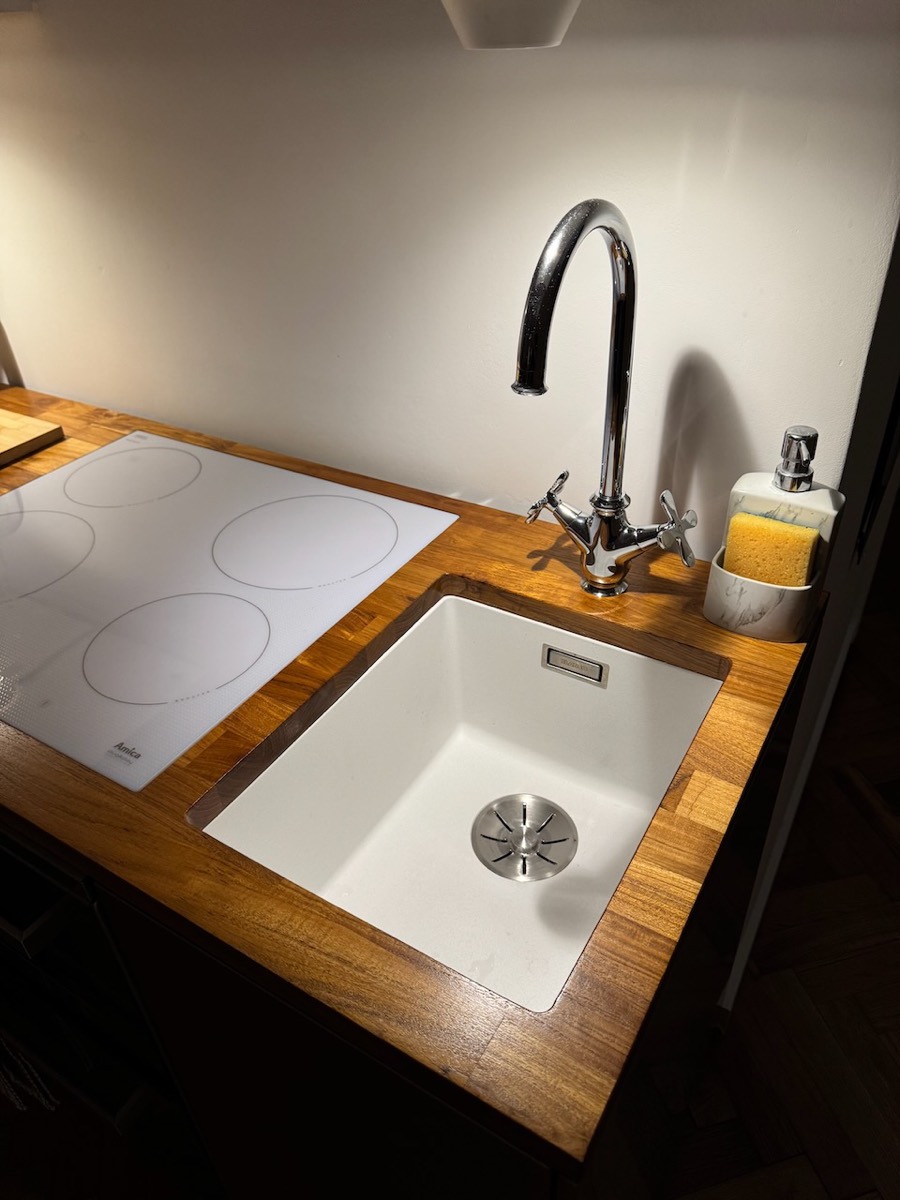 White induction hob and undermount sink set into an oak worktop